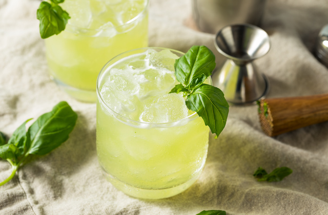 GIn Basil Smash im Glas serviert mit Eiswürfeln und Basilikumblättern