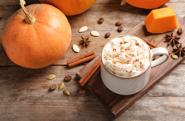 Pumpkin Spice Latte in Tasse neben Kürbis