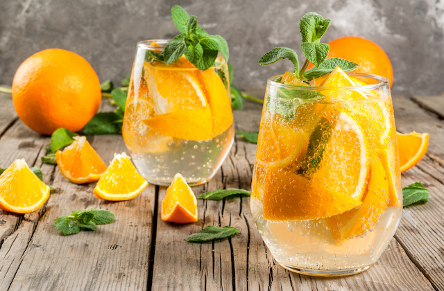 Orangenlimonade im Glas mit Orangen und Minze