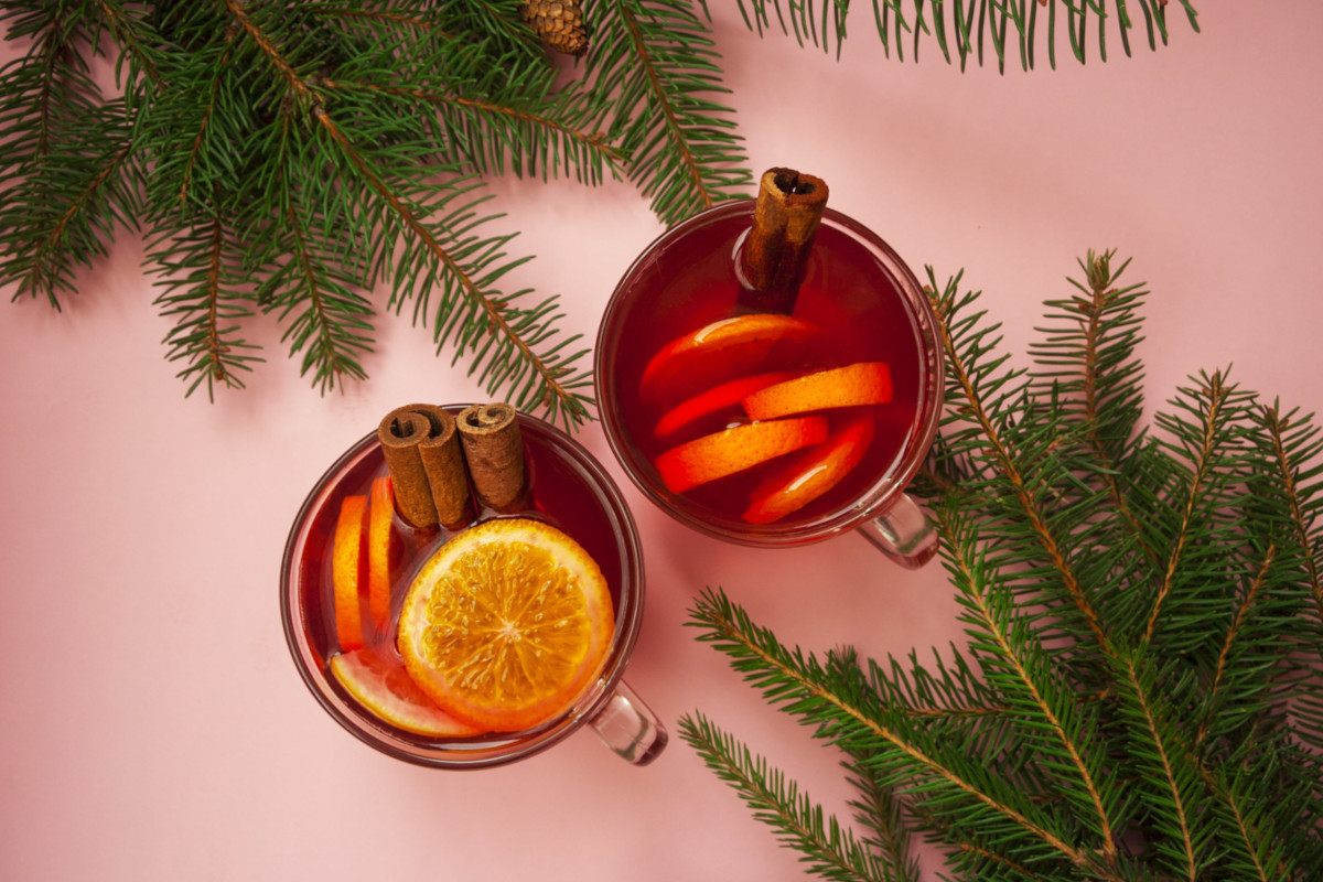 Roter Glühwein mit Orangenscheiben und Zimtstangen 