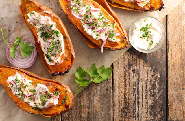 Gebackene Ofen-Süßkartoffeln mit Aioli und Zwiebeln auf Tisch