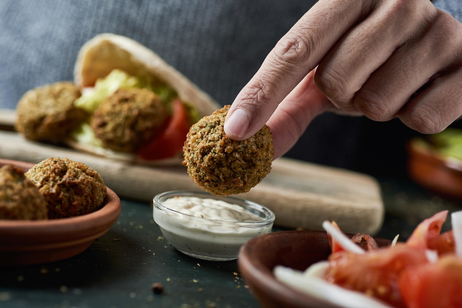 Falafel wird in Sauce gedippt