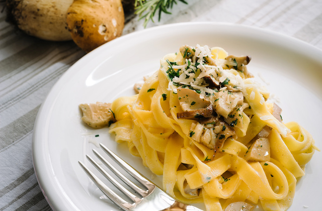 Fettuccine mit Steinpilzsauce und Parmesan angerichtet auf Teller