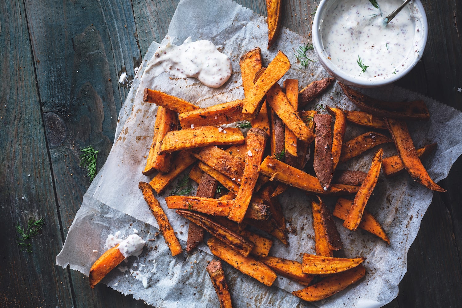 Süßkartoffel Pommes auf Tisch mit Sour Cream Dip