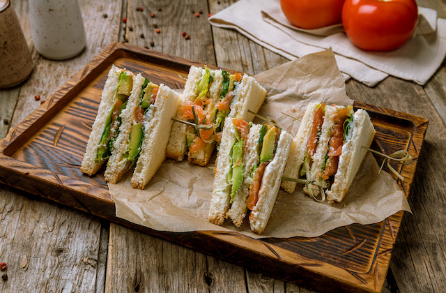 Lachs Sandwich mit Avocado auf Holzbrett serviert