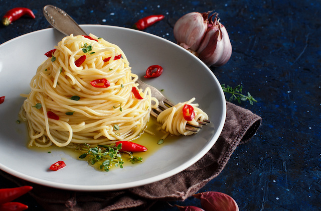 Aglio e Olio Pasta angerichtet auf Teller mit Knoblauch und Chilis