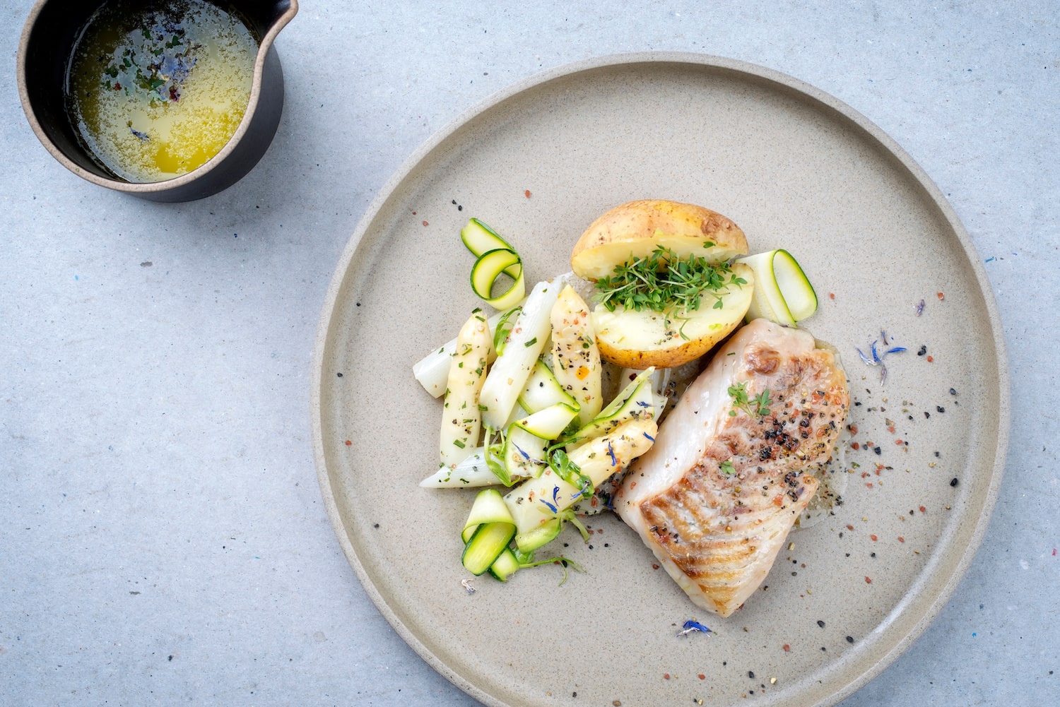 Kabeljau mit Spargel, Gemüse und Kartoffeln auf Teller