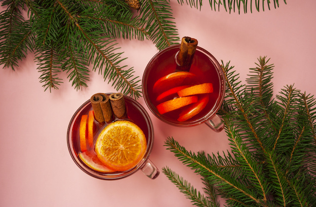 Glühwein in Tassen  mit Orangen und Zimt