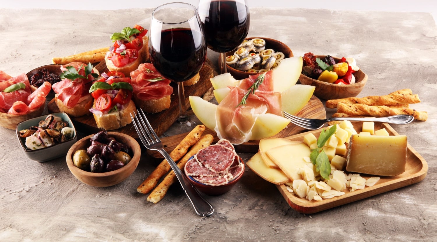 Antipasti Platte mit Bruschetta, Käse, Obst und Rotwein