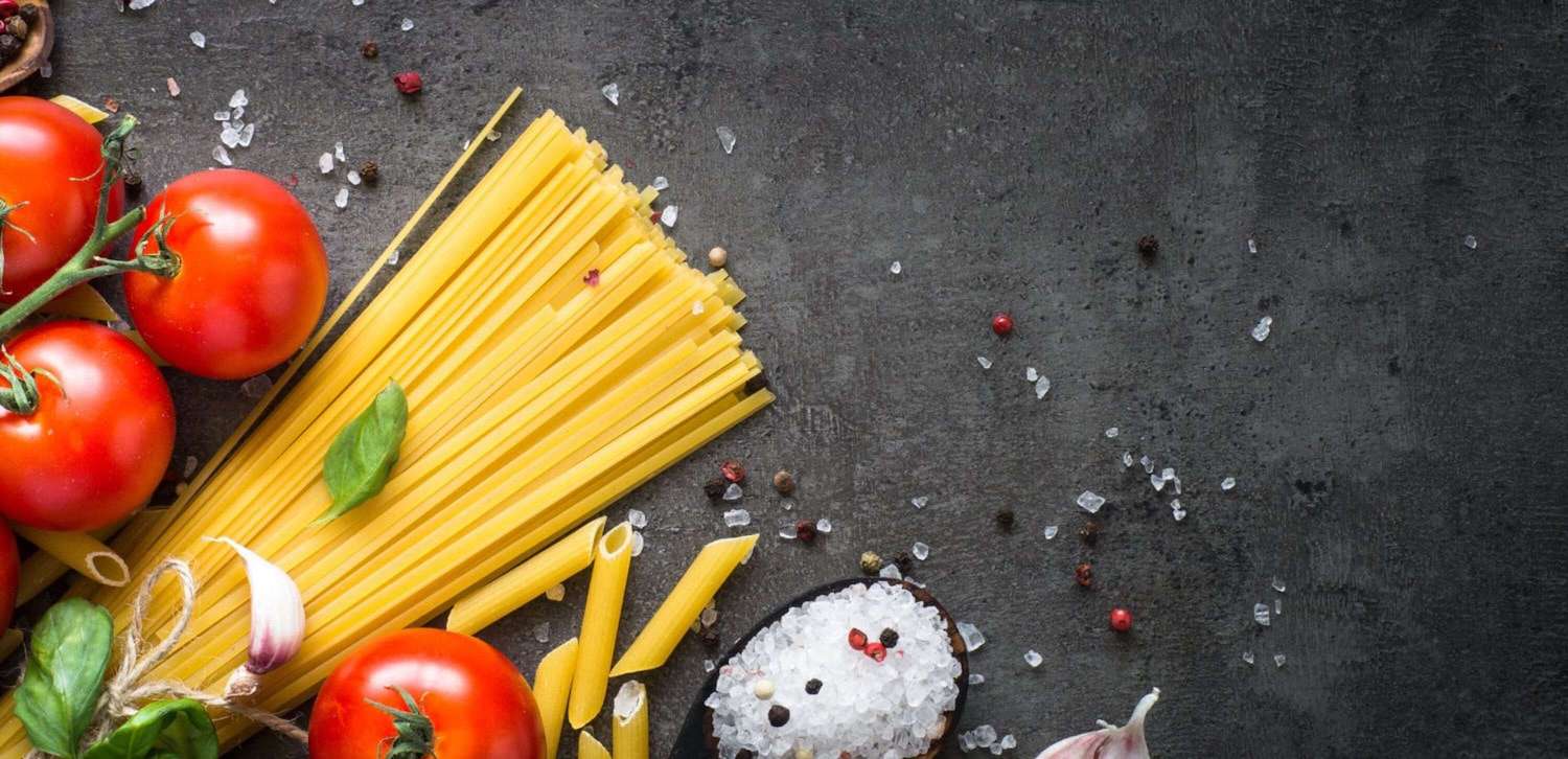 Spaghetti, Tomaten & Gewürze auf grauem Tisch