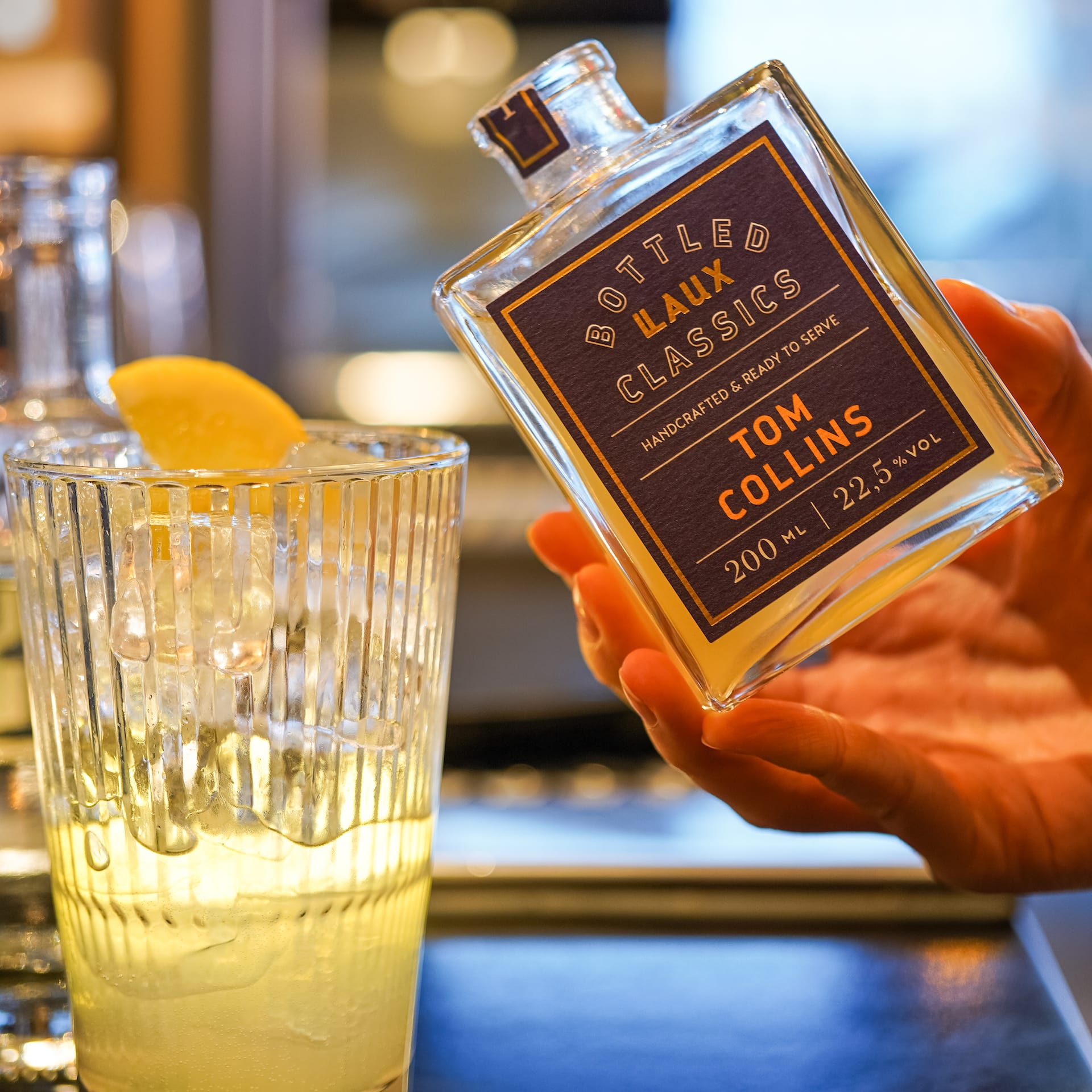 LAUX Tom Collins wird ins Cocktail Glas gegossen