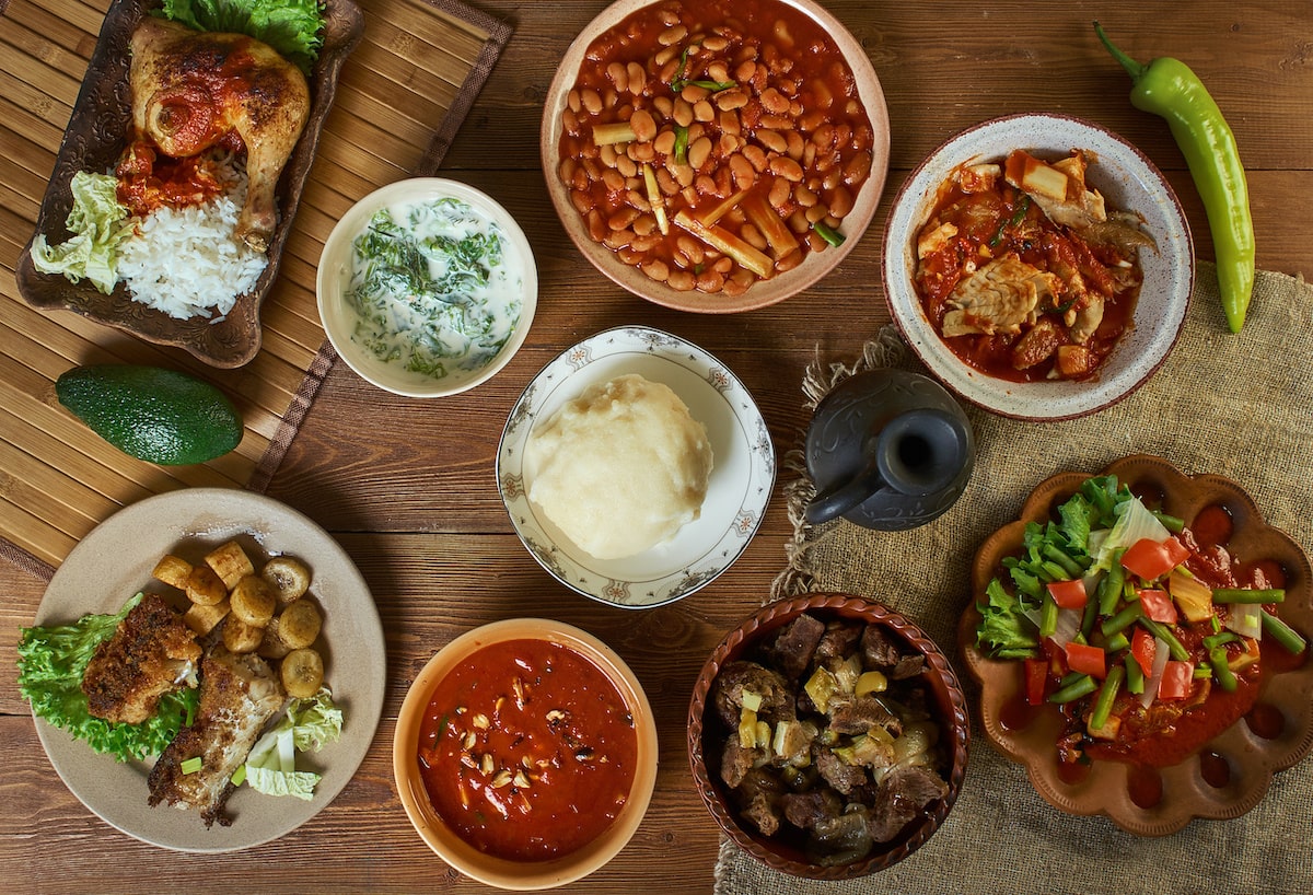 Afrikanisches Essen mit Fleisch, Reis und Gemüse in Schüsseln auf Tisch