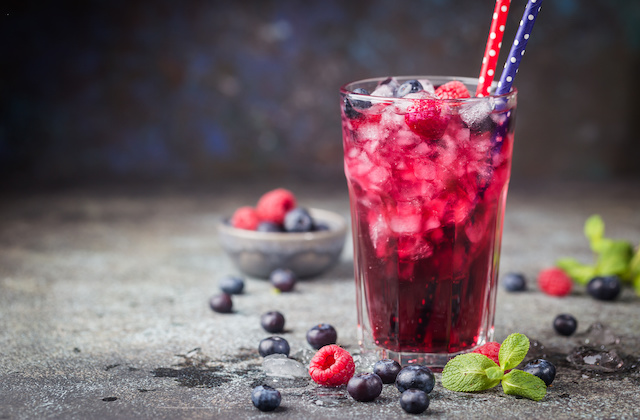 Frühlingsbowle mit Gin, Heidelbeeren, Himbeeren und Minze angerichtet in Glas