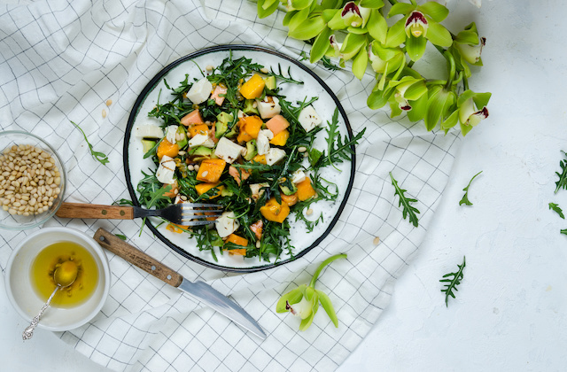 Caprese mit Rucola und Mango angerichtet auf Teller