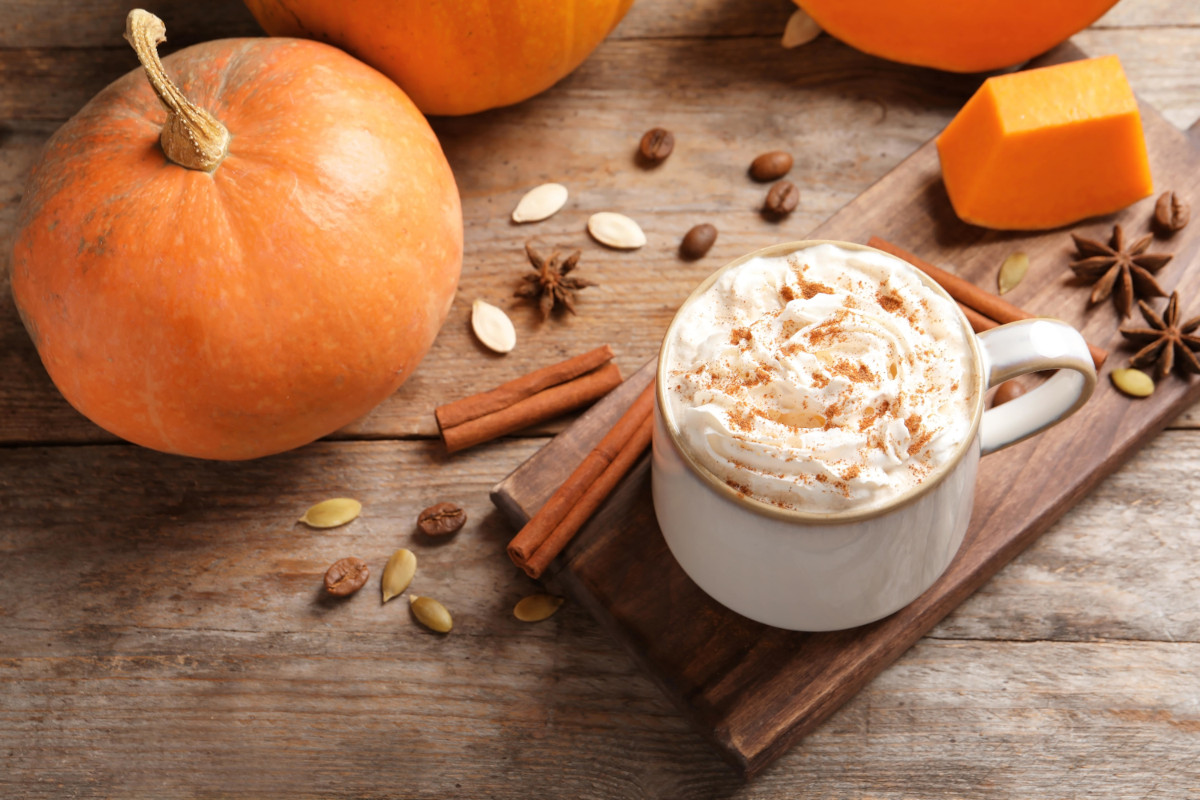 Pumpkin Spice Latte auf Tisch neben Kürbis und Gewürzen