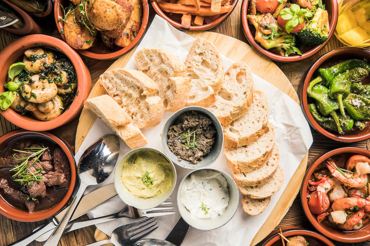 Spanische Tapas mit Baguette und Aioli auf Holzbrett