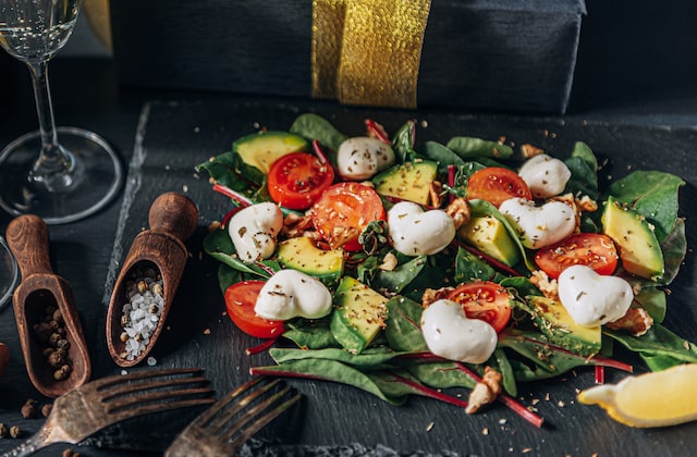 Salat mit Avocado, Tomaten und Mozzarella-Herzen auf Schiefernplatte