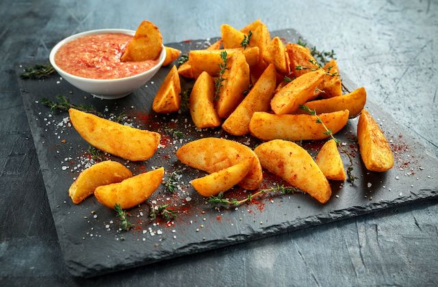 Cajun Potatoe Wedges angerichtet auf Schiefernplatte