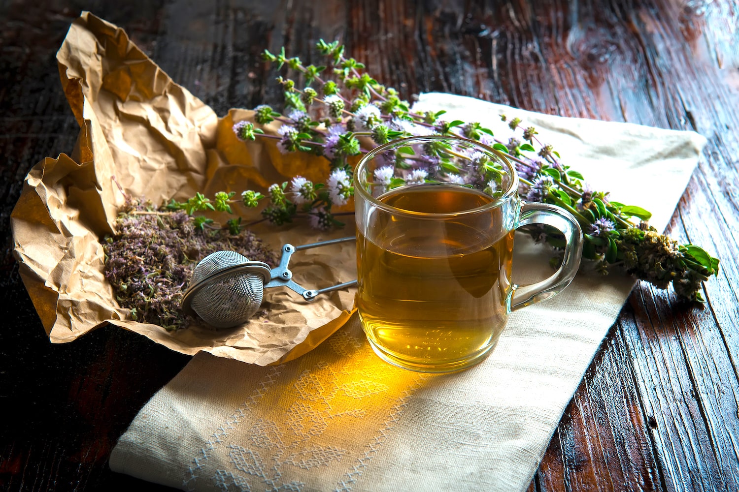 Kräutertee im Glas mit Kräutern auf Tisch