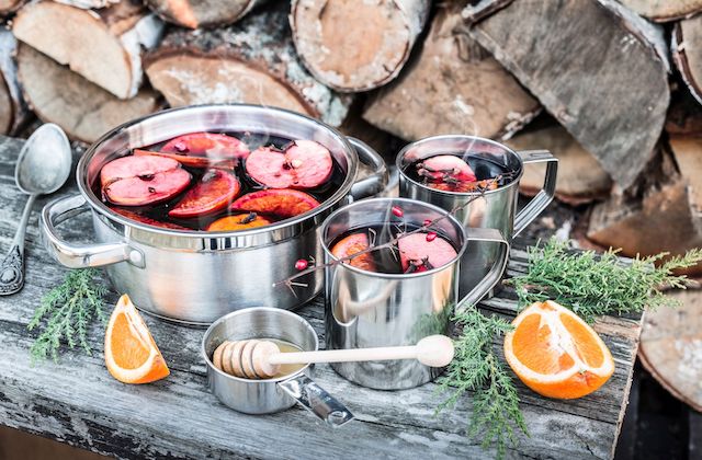 Winterapfel Punsch mit Äpfeln, Orangen und Honig auf Holztisch