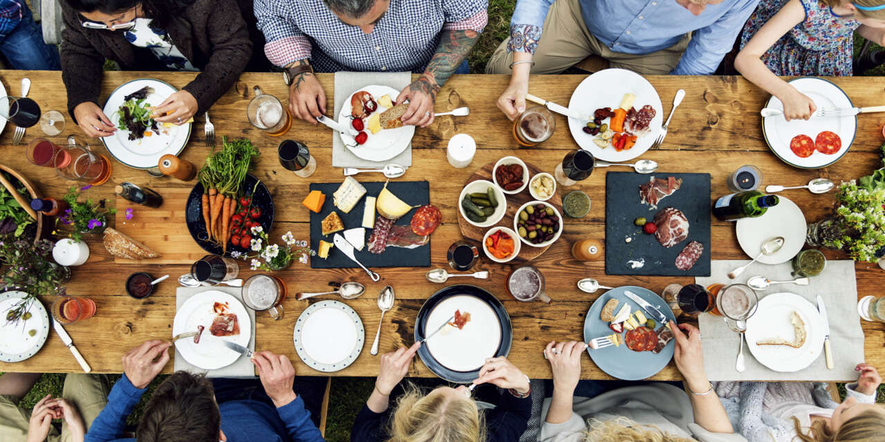 Männer die an einem Tisch sitzen und essen