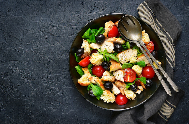 Brotsalat mit Tomaten, Oliven, Ciabatta und Salat in Schüssel