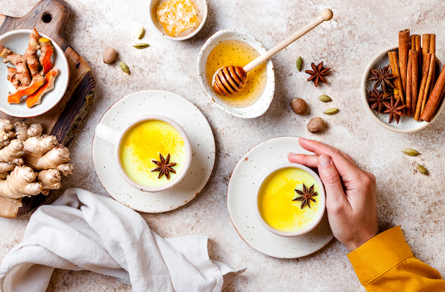 Goldene Milch in Tassen mit Ingwer, Kurkuma und Honig